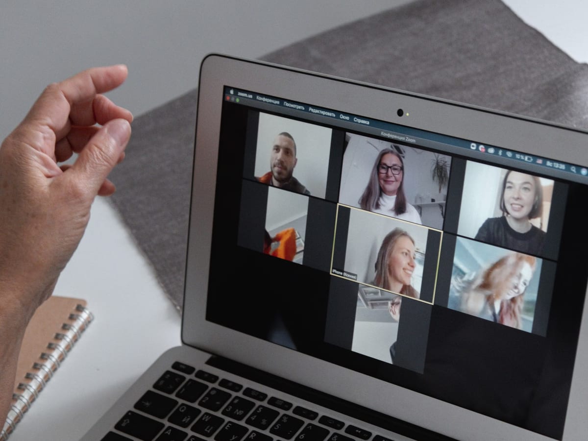 A laptop screen showing a grid of colleagues taking part in a video call